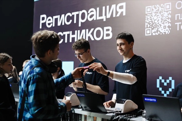 Гости получают бейджи у стойки под баннером «Регистрация участников»