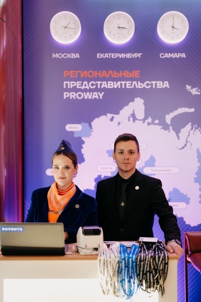 Стойка регистрации с рядом лент на карабинах и принтером бейджей на форуме
